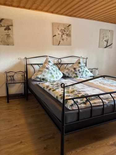 a bed with a black frame and pillows on it at Ferienhaus Eifelperle in Blankenheim