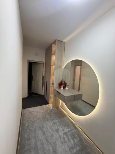 a hallway with a circular mirror and a sink at Olmazor Comfort in Qoraqamish