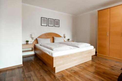 a bedroom with a large wooden bed in it at Ferienwohnungen Steinbacher in Vogtareuth