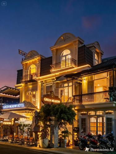 a large white building with a sign in front of it at Green Meadow Serenity - Center Hotel in Da Lat