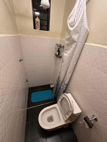 a small bathroom with a toilet in a stall at The T Cottage in Othaya
