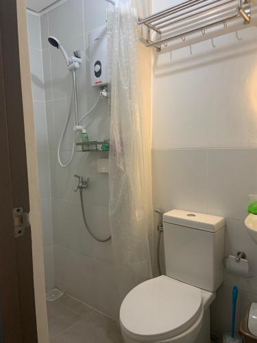 a bathroom with a shower with a toilet and a sink at Bright Nook in Manila