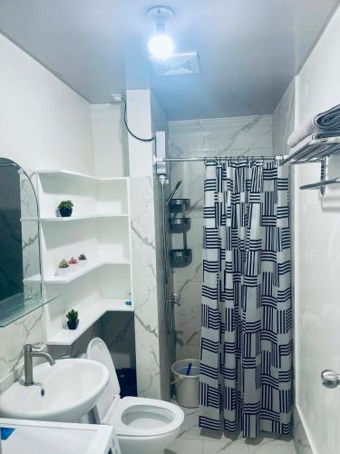 a bathroom with a shower and a toilet and a sink at NagaCityRiverView 2BR Apartment in Naga