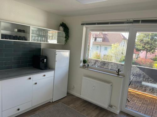 a kitchen with a white refrigerator and a window at Hostel by BookieBooking in Wiesbaden
