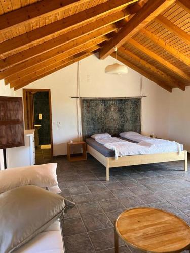 a bedroom with two beds and a table at Moinhos do Paneiro in Santiago do Cacém