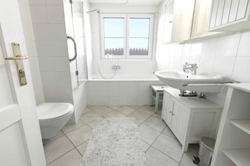 a white bathroom with a sink and a toilet at Rosi's Ferienwohnung im Haus Sieglinde in Prien am Chiemsee