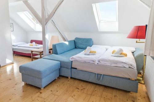 a room with a bed and a blue couch at Rosi's Ferienwohnung im Haus Sieglinde in Prien am Chiemsee