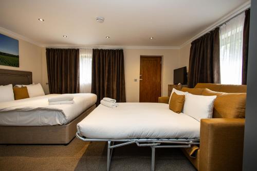 a hotel room with two beds and a couch at Terlingham Lane Cottage in Folkestone