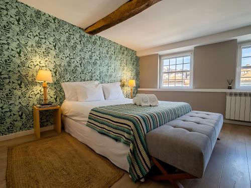 a bedroom with a bed with a green wall at Secret Garden in Bragança - historic center in Bragança