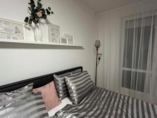 a bedroom with a bed with pillows and a window at Harmony Apartman in Dunajská Streda