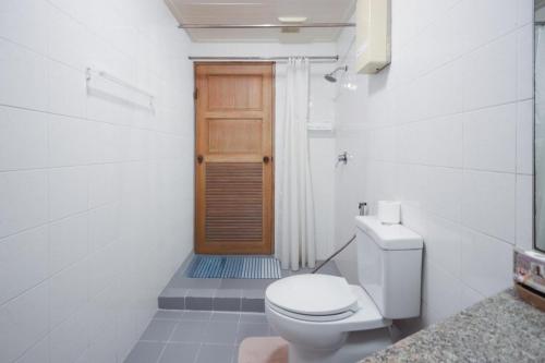 a bathroom with a toilet and a wooden door at Sky beach view in North Pattaya