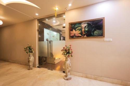 a room with two vases with flowers and a painting at Hotel Krishnam Vrindavan in Vrindāvan