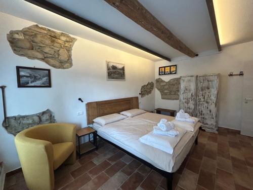 a bedroom with a bed and a chair in it at Castrum Gallani in Barberino di Mugello