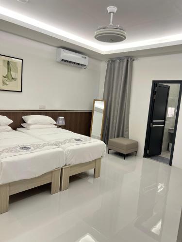 a bedroom with two beds and a mirror at Foavahi Shark View Inn in Fuvahmulah