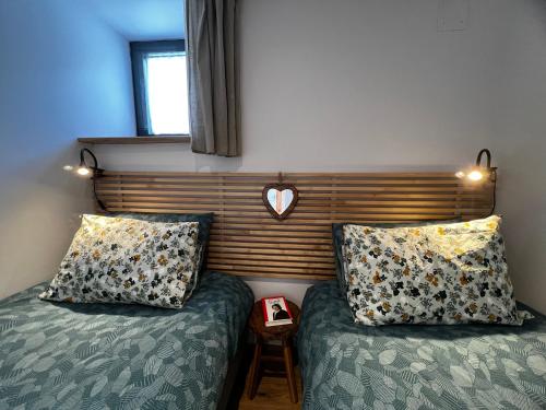 a bedroom with two beds and a wooden headboard at Gîte de Charme in Saint-Avit-de-Tardes