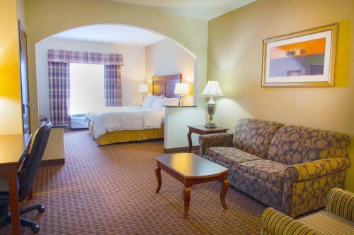a hotel room with a couch and a bed at Holiday Inn Express Hotel & Suites Center by IHG in Center