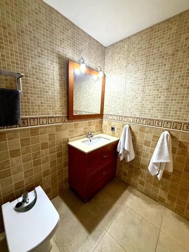 a bathroom with a sink and a toilet and a mirror at Ocean Breath Home in L'Ametlla de Mar
