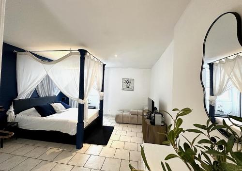 a bedroom with a canopy bed and a mirror at Nuit En Brenne in Le Blanc