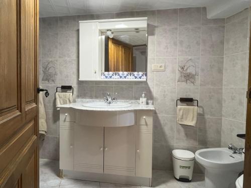 a bathroom with a sink and a toilet and a mirror at Casa Jardin in Lobras