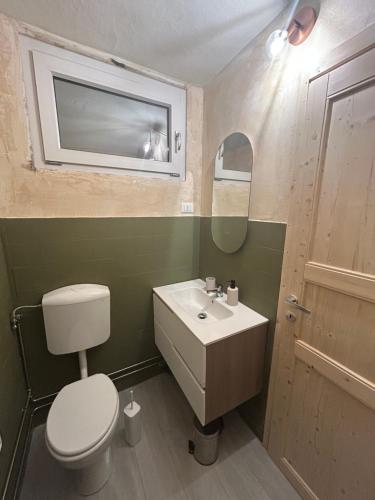 a bathroom with a toilet and a sink and a mirror at Il caminetto in Pradleve