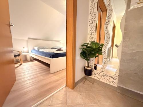 a bedroom with a bed and a potted plant at Apartments in Green House in Bovec