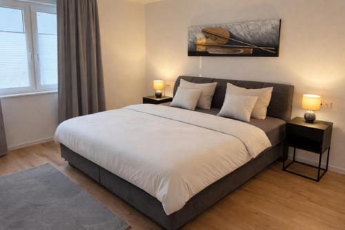 a bedroom with a large bed with two lamps on tables at Moderne Wohnung am Flussufer in Herford