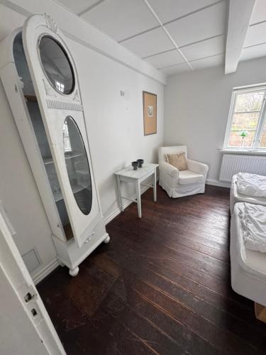 a room with a mirror and a couch and a table at Skelby Præstegård lej 2 in Gedser
