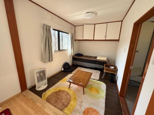 a small living room with a table and a couch at 久住みんなの森ロッジ202号-Kuju Forest Retreat 最大4名 in Kokonoe