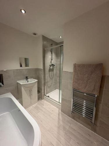 a bathroom with a tub and a shower and a sink at Whistle Stop Terrace in Barnby Dun