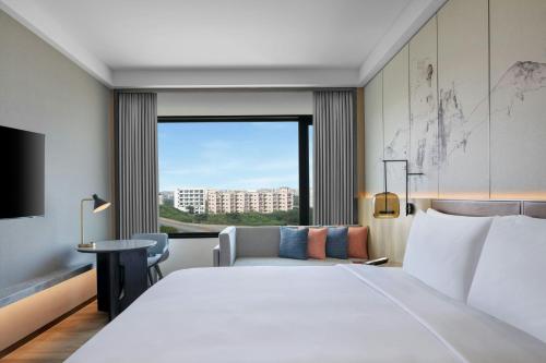 a hotel room with a large bed and a window at Courtyard By Marriott Tirupati in Tirupati