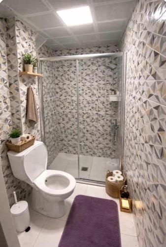 a bathroom with a toilet and a glass shower at Soydan World Travel in Antalya