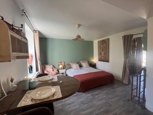 a bedroom with a bed and a table in it at La mésAnges in Giverny