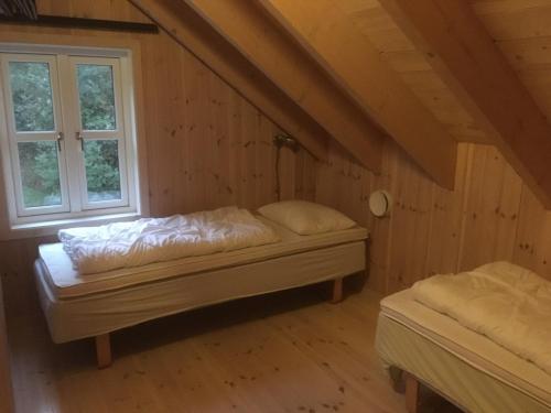 a room with two beds and a window at Konstali Gard in Flekkefjord