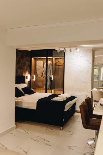 a bedroom with a large bed and a chair at Apartman Prime - free parking in Belgrade