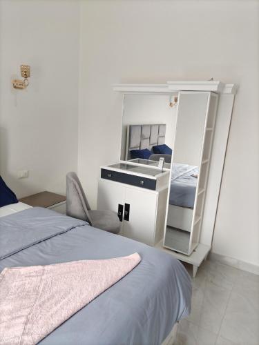 a bedroom with a bed and a desk and a mirror at realistic country guest house in Al Aqālitah