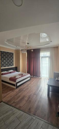 a bedroom with a large bed and a wooden floor at MAHALI HOTEL in Batumi