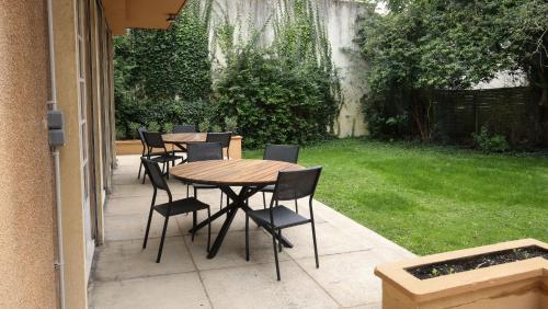 a wooden table and chairs on a patio at Erawan Boutique Hôtel in Évreux