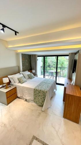 a bedroom with a large bed and a balcony at Pousada Baixa Verde in Triunfo