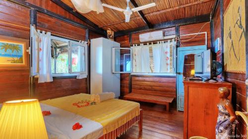 a bedroom with a bed and a table in a room at Villa Razambe in Mandriankeniheny