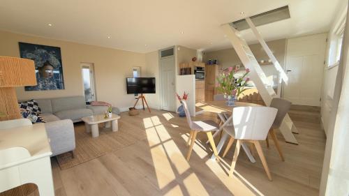 a living room with a couch and a table and chairs at Tulipa Near Beach & Dunes with Free Parking in Noordwijkerhout