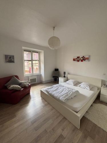 a bedroom with a white bed and a couch at Riquewihr in Riquewihr