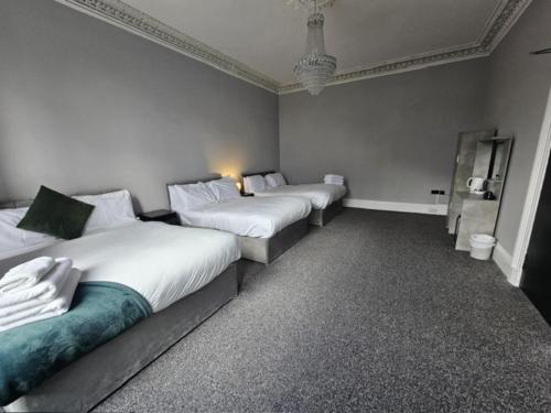 two beds in a room with white walls at Edinburgh City Hotel in Edinburgh