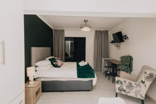 a bedroom with a bed and a desk and a chair at Seek First B&B in Pretoria