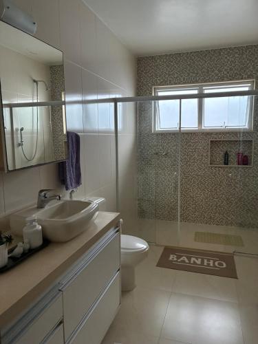 a bathroom with a sink and a toilet and a shower at Casa Au Clair de Lune Terê in Teresópolis