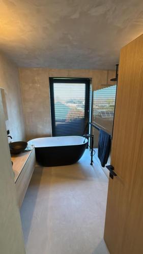 a bathroom with a large tub and a window at Executive Villa with pool in Londerzeel