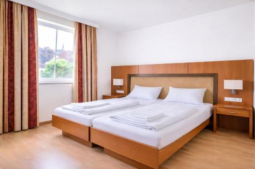 a bedroom with a large bed with a large window at Mühlengarten by Zzzimple in Nittel