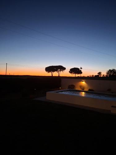 a sunset with three trees in the background at Casa dos Foros in Odemira