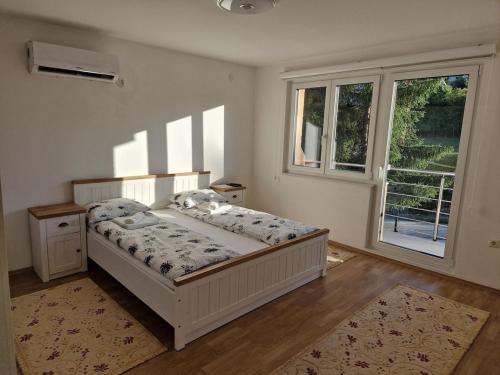 a bedroom with a bed in a room with windows at Villa Oaza Vilenjak in Visoko