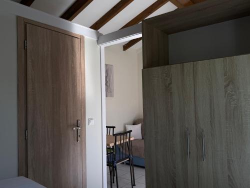 a room with wooden cabinets and a room with a table at Vasiliki Little House in Kanoni