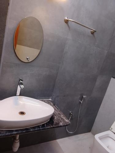 a bathroom with a sink and a mirror on the wall at HoTEL K7 in Chennai